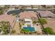 An aerial view of a home with a pool, covered patio, tile roof, and desert landscaping in a residential area at 7719 Villa Montara St, Las Vegas, NV 89123