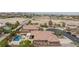 An aerial view of a home with a pool, covered patio, tile roof, in a desert residential area at 7719 Villa Montara St, Las Vegas, NV 89123