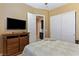 Neutral bedroom with dresser, tv, mirrored closet doors, and comfortable looking bed at 7719 Villa Montara St, Las Vegas, NV 89123