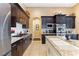 Kitchen with dark wood cabinetry, granite countertops and stainless steel appliances at 7719 Villa Montara St, Las Vegas, NV 89123