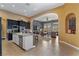 Open kitchen with dark cabinets, granite countertops, stainless steel appliances, and view to the living room at 7719 Villa Montara St, Las Vegas, NV 89123