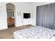 Comfortable bedroom featuring a dresser with a TV, carpeted floors, and a view of the attached bathroom, creating a private retreat at 9303 Gilcrease Ave # 1077, Las Vegas, NV 89149