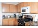 Functional kitchen showcasing granite countertops, wood cabinets, and modern appliances, offering a practical cooking space at 9303 Gilcrease Ave # 1077, Las Vegas, NV 89149