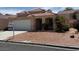 Inviting single-story house featuring a well-kept yard with desert landscaping and a convenient two-car garage at 951 Country Back Rd, Las Vegas, NV 89123