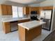 Bright kitchen equipped with stainless steel appliances, an island, and white tile countertops at 951 Country Back Rd, Las Vegas, NV 89123