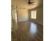 Bright living room with laminate floors, a ceiling fan, and a large window at 951 Country Back Rd, Las Vegas, NV 89123