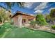 A beautifully landscaped backyard features a covered patio, putting green, and lush foliage, creating an inviting outdoor retreat at 9713 Highridge Dr, Las Vegas, NV 89134