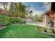 A lush backyard showcases a waterfall feature and provides a serene and private outdoor living space with verdant landscaping at 9713 Highridge Dr, Las Vegas, NV 89134