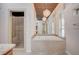 Bathroom featuring a soaking tub, shower, and decorative chandelier lighting at 9713 Highridge Dr, Las Vegas, NV 89134