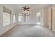 Sunlit primary bedroom features neutral carpet, multiple windows, and access to the patio at 9713 Highridge Dr, Las Vegas, NV 89134