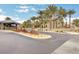 Landscaped entrance to Mountain Trails featuring palm trees, shrubs and a stone monument sign at 9713 Highridge Dr, Las Vegas, NV 89134