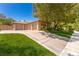 Well-maintained house featuring a three-car garage, lush green lawn, and mature trees enhancing curb appeal at 9713 Highridge Dr, Las Vegas, NV 89134