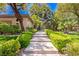 Beautiful walkway leading to a private residence with lush landscaping and mature trees at 9713 Highridge Dr, Las Vegas, NV 89134