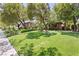 Beautifully landscaped front yard with a large green lawn, mature trees, and manicured bushes enhancing the home's curb appeal at 9713 Highridge Dr, Las Vegas, NV 89134
