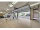Large garage with high ceilings, exercise equipment, and an open door leading to the driveway at 9713 Highridge Dr, Las Vegas, NV 89134