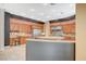 Spacious kitchen with custom wood cabinets, granite countertops, stainless steel appliances, and bar seating at 9713 Highridge Dr, Las Vegas, NV 89134