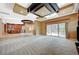 Expansive living room with unique ceiling design, travertine steps leading to kitchen, and sliding door access to patio at 9713 Highridge Dr, Las Vegas, NV 89134