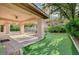 The home features a covered patio with a putting green and mature landscape, ideal for outdoor activities at 9713 Highridge Dr, Las Vegas, NV 89134