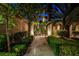 Inviting walkway leading to the home's entrance, framed by lush greenery, mature trees, and manicured landscaping details at 9713 Highridge Dr, Las Vegas, NV 89134