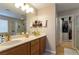 Bright bathroom showcasing double sinks, wood cabinets, a large mirror, and a walk-in closet at 9925 Turquoise Glass Ct, Las Vegas, NV 89178