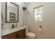 Bathroom with rustic wood vanity, granite countertop, decorative lighting, and a window at 9925 Turquoise Glass Ct, Las Vegas, NV 89178