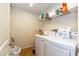 Bright laundry room with white washer and dryer, shelving, and neutral tile flooring at 9925 Turquoise Glass Ct, Las Vegas, NV 89178