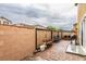 Enclosed patio with brick pavers, wood bench, grill, and view of neighboring homes at 9925 Turquoise Glass Ct, Las Vegas, NV 89178