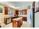 Well-lit kitchen with granite countertops, stainless steel appliances, a kitchen island, and cherry wood cabinets at 10931 Sardinia Sands Dr, Las Vegas, NV 89141