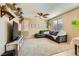 Bright living room featuring a comfortable gray sectional, neutral carpet, ceiling fan, and natural light from multiple windows at 10931 Sardinia Sands Dr, Las Vegas, NV 89141