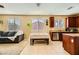 Open living area combines the living room with a gray sectional, neutral carpet, and the eat-in kitchen at 10931 Sardinia Sands Dr, Las Vegas, NV 89141