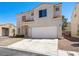 Two-story home with a two-car garage, stucco exterior and tile roof at 1153 Stormy Valley Rd, Las Vegas, NV 89123