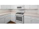 Close-up view of the kitchen featuring white cabinets, tile countertop, and updated appliances at 1153 Stormy Valley Rd, Las Vegas, NV 89123