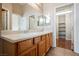 Bathroom featuring double sinks, wood cabinets, and access to walk-in closet at 1580 Wild Willey Way, Henderson, NV 89002