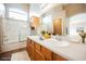 Bathroom featuring double sinks, a shower with glass doors, wood cabinets and tile flooring at 1580 Wild Willey Way, Henderson, NV 89002