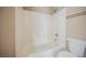 Bathroom showcasing white tile shower-over-tub combo and matching white toilet at 1580 Wild Willey Way, Henderson, NV 89002