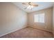 Bright, empty bedroom features a ceiling fan, carpeted floors, and a large window at 1580 Wild Willey Way, Henderson, NV 89002