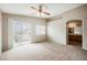 Spacious carpeted bedroom featuring ceiling fan and balcony access at 1580 Wild Willey Way, Henderson, NV 89002