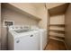 Bright laundry room featuring a washer, dryer, and built-in shelving at 1580 Wild Willey Way, Henderson, NV 89002