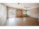 Bright living room with a ceiling fan, sliding glass doors, and neutral paint at 1580 Wild Willey Way, Henderson, NV 89002