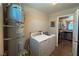 Modern laundry room with white appliances, tile flooring, and a view into the kitchen at 1800 Edmond St # 218, Las Vegas, NV 89146