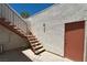 Outdoor stairway with carpeted steps, metal railing, stucco walls, and a brown door at 1800 Edmond St # 218, Las Vegas, NV 89146