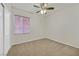 Bright, minimalist bedroom with a neutral color scheme, carpet flooring, window with blinds, and a spacious closet at 2309 Tedesca Dr, Henderson, NV 89052