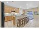 Bright kitchen featuring wooden cabinets, tiled floor, and a breakfast bar with wooden stools at 2309 Tedesca Dr, Henderson, NV 89052