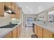 Galley kitchen features gas range, light wooden cabinetry, white countertops, and a view to dining area at 2309 Tedesca Dr, Henderson, NV 89052