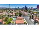 An aerial view captures a residential neighborhood with mature trees and a stunning view of the Las Vegas skyline at 2704 Miraflores Ave, Las Vegas, NV 89102