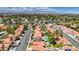 A sprawling community featuring lush landscaping, and multiple homes with red tiled roofs, complemented by desert mountain views at 2704 Miraflores Ave, Las Vegas, NV 89102