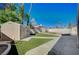 Backyard featuring artificial turf, a shed, a cinderblock wall, and mature landscaping at 2704 Miraflores Ave, Las Vegas, NV 89102