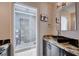 Bathroom showcasing a glass-enclosed shower, granite countertops, and dark wood cabinetry at 2704 Miraflores Ave, Las Vegas, NV 89102