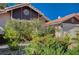 Landscaped front yard with vibrant blooming bushes and a well maintained terra cotta tile roofline at 2704 Miraflores Ave, Las Vegas, NV 89102