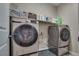 A modern laundry room showcases updated washer and dryer units with storage space and baskets above at 28 Verde Rosa Dr, Henderson, NV 89011